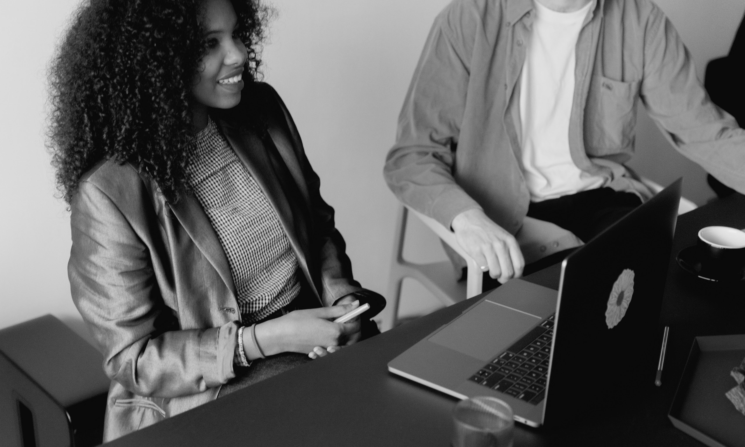 Person at computer holding mobile phone hybrid working