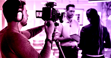 Cameraman films a businessman talking to a businesswoman