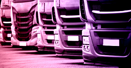 Front of row of parked lorries with pink and purple tinge