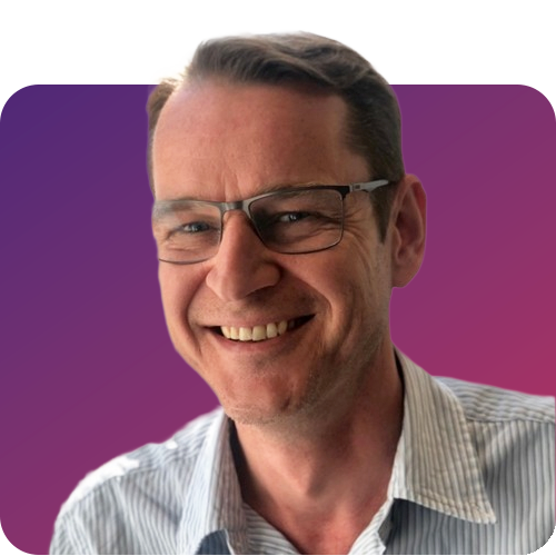 Professional headshot of a smiling man wearing glasses and a striped shirt against a purple and magenta gradient background.